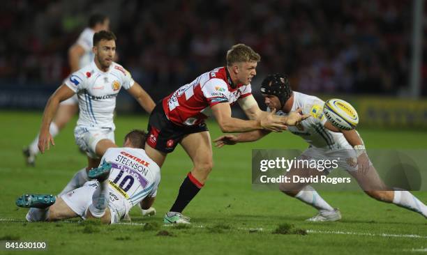 Ollie Thorley of Gloucester off loads the ball as Gareth Steenson tackles during the Aviva Premiership match between Gloucester Rugby and Exeter...