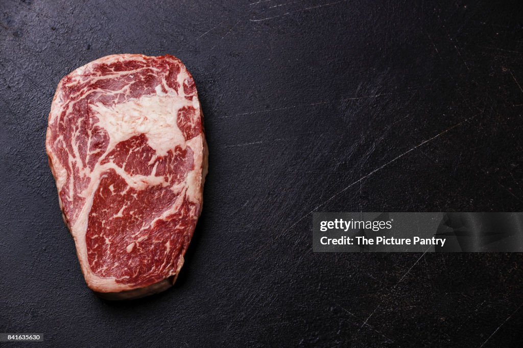 Raw fresh marbled meat Steak Rib eye Black Angus on dark background copy space