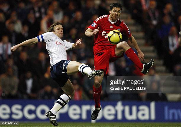 Liverpool's Spanish midfielder Xabi Alonso and Preston North End's English midfielder Paul McKenna compete for the ball during their English FA Cup...