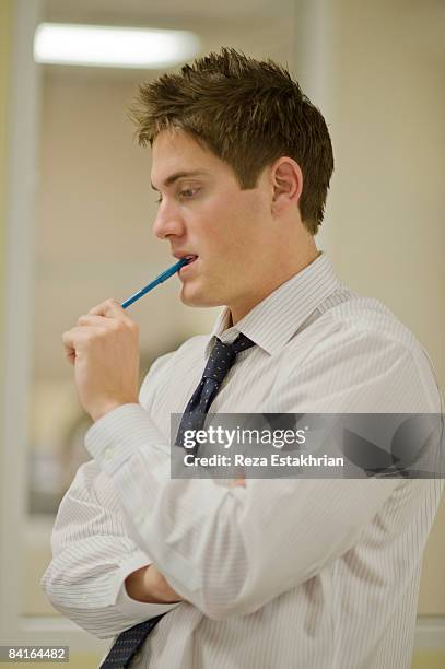 young businessman in deep thought - ballpoint pen stock pictures, royalty-free photos & images