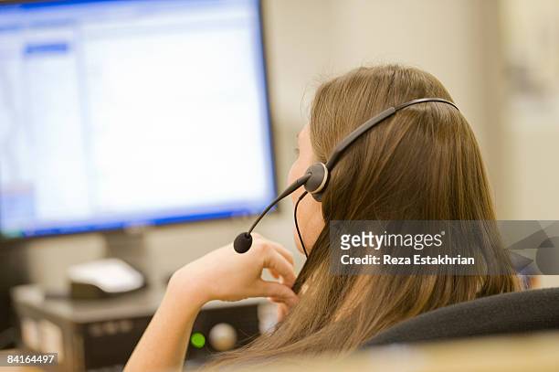 woman in call center on phone - agente de servicio al cliente fotografías e imágenes de stock