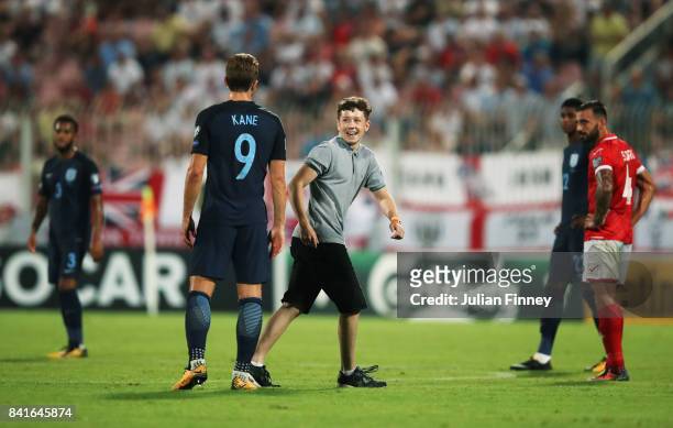Pitch invader smiles at Harry Kane of England during the FIFA 2018 World Cup Qualifier between Malta and England at Ta'Qali National Stadium on...
