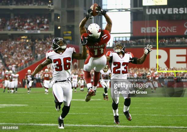 Wide receiver Larry Fitzgerald of the Arizona Cardinals makes a leaping 42 yard touchdown reception over Lawyer Milloy and Chris Houston of the...