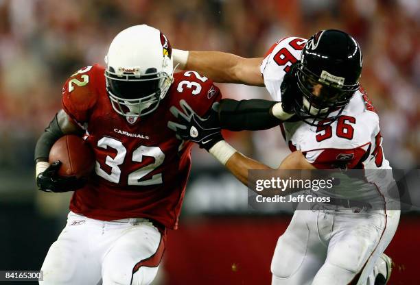 Runningback Edgerrin James of the Arizona Cardinals fights off a tackle from Keith Brooking of the Atlanta Falcons as he rushes the ball during the...