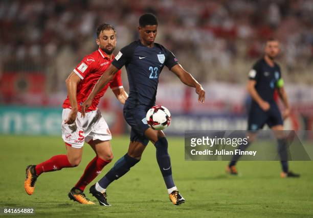 Marcus Rashford of England holds off Andrei Agius of Malta during the FIFA 2018 World Cup Qualifier between Malta and England at Ta'Qali National...