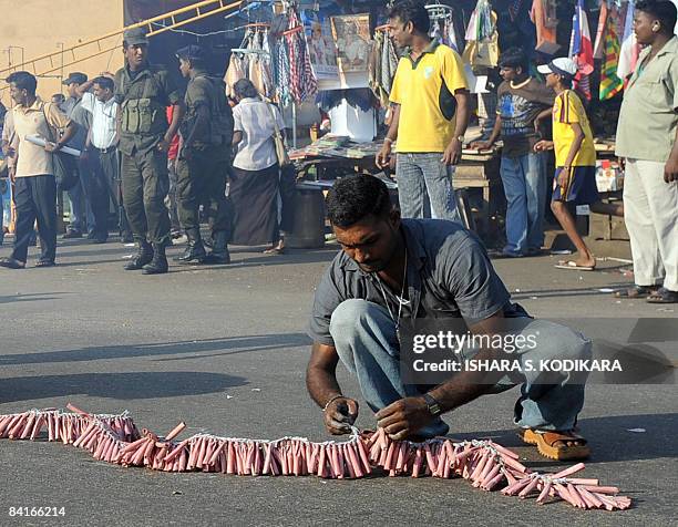 Sri Lankan people prepare to light fire crackers in Colombo on January 2 to celebrate the military capturing the northern town of Kilinochchi on...
