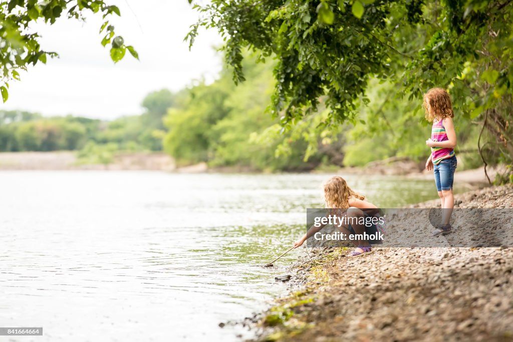 Zwei junge Mädchen spielen im Ufer des Mississippi