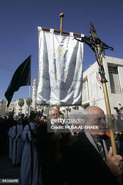 Palestinian Catholic Christians and other residents march carrying a crucifix and a black flag after Sunday mass from the Church of the Nativity in...