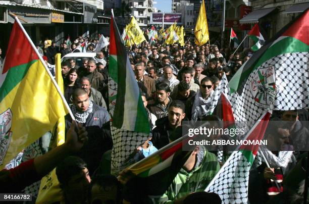 Palestinian demonstrators hold up their national flag and Fatah flags as they chant anti Israeli slogans during a protest against Israel's military...