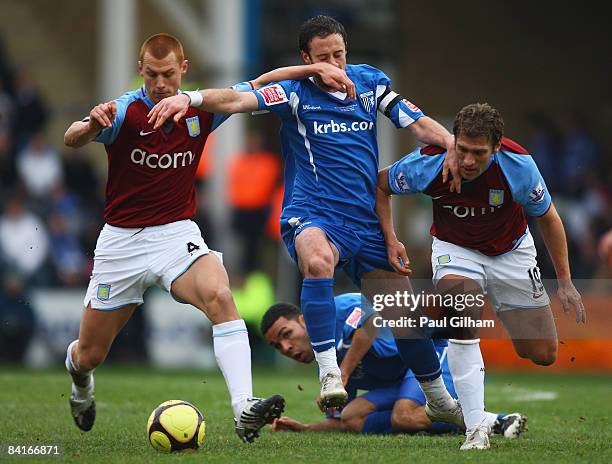 Adam Miller of Gillingham battles for the ball with Steve Sidwell and Stiliyan Petrov of Aston Villa during the FA Cup sponsored by E.on third round...