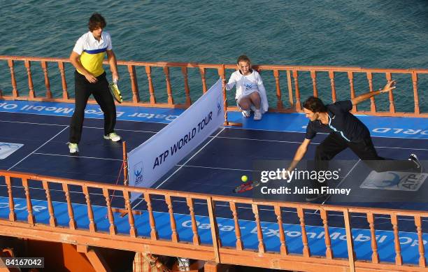 Rafael Nadal of Spain and Roger Federer of Switzerland play tennis on top of a Dhow in Doha Bay to launch the 2009 ATP World Tour during previews for...