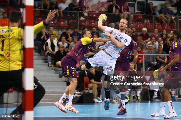 Jonas Truchanovicius of Montpellier Handball is shooting the ball against Dominik Klein, Rock Feliho and Cyril Dumoulin of HBC Nantes during the...