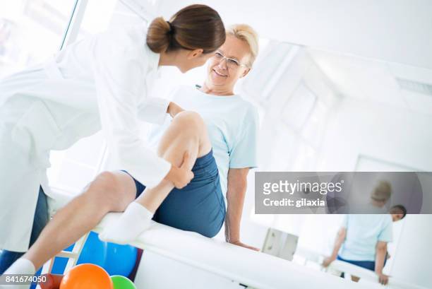 senior vrouw na onderzoek van de knie. - medische onderzoekskamer stockfoto's en -beelden