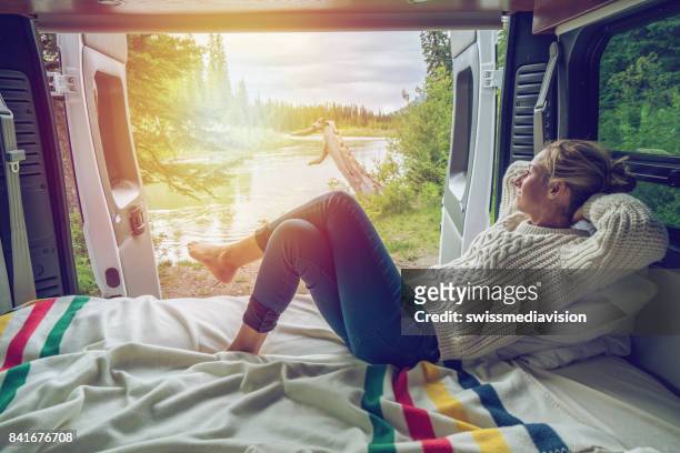 young woman having a stunning view out of the back of her camping van - rv stock pictures, royalty-free photos & images