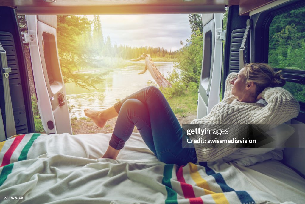 Young woman having a stunning view out of the back of her Camping Van