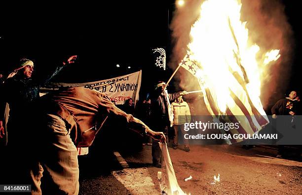 Pro-Palestinian protestors burn a US flag outside the US embassy in Athens during a protest march towards Israel's embassy in Athens on January 4,...