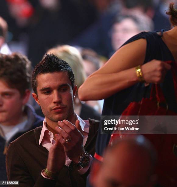 Arsenal football player Robin Van Persie looks on at Phil Taylor of England during his Final match against Raymond Van Barneveld of the Netherlands...