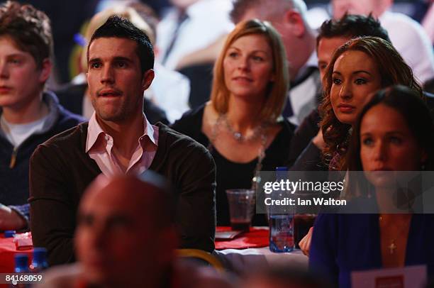 Arsenal football player Robin Van Persie looks on at Phil Taylor of England during his Final match against Raymond Van Barneveld of the Netherlands...