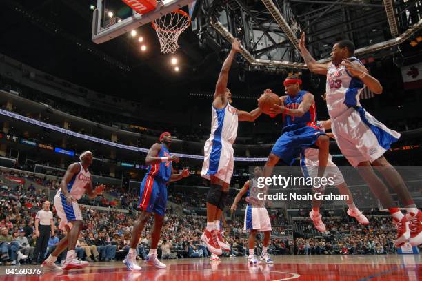 Allen Iverson of the Detroit Pistons leaves his feet to make a pass between Brian Skinner and Marcus Camby of the Los Angeles Clippers at Staples...