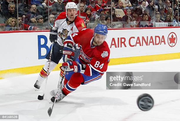 Bryan McCabe of the Florida Panthers dumps the puck out as Guillaume Latendresse of the Montreal Canadiens keeps an eye on it during their NHL game...