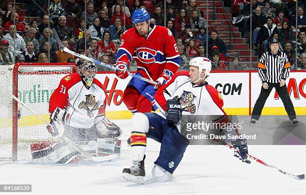 Tom Kostopoulos of the Montreal Canadiens leaps through the crease as Craig Anderson of the Florida Panthers moves into position while his teammate...