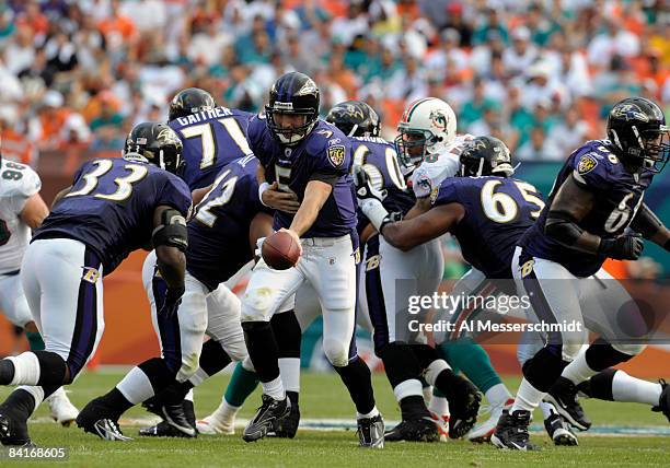 Quarterback Joe Flacco of the Baltimore Ravens hands off to running back Le'Ron McClain against the Miami Dolphins during their AFC Wild Card Game at...