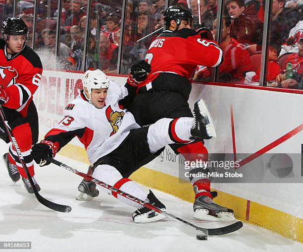 Jarkko Ruutu of the Ottawa Senators falls to the ice trying to control the puck against Dainius Zubrus of the New Jersey Devils at the Prudential...