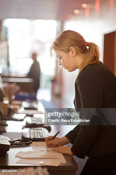 hotel receptionist writes notes - pre reception stockfoto's en -beelden