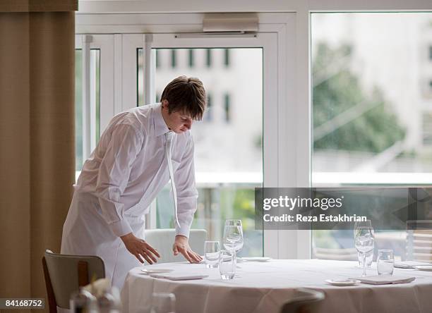 waiter sets flatware in precise positions - waiter stock-fotos und bilder