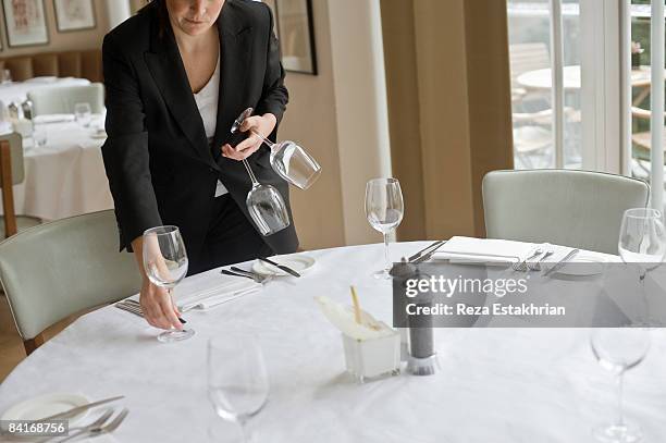 woman setting out wine glasses in restaurant - waiter stock pictures, royalty-free photos & images