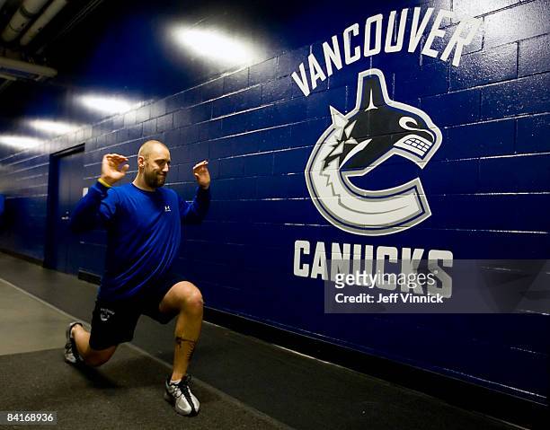 Jason LaBarbera of the Vancouver Canucks stretches in the hallway outside the team dressing room before their game against the Dallas Stars at...