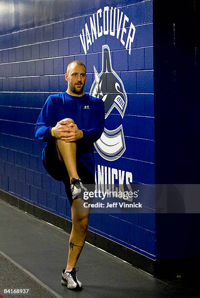 Jason LaBarbera of the Vancouver Canucks stretches in the hallway outside the team dressing room before their game against the Dallas Stars at...