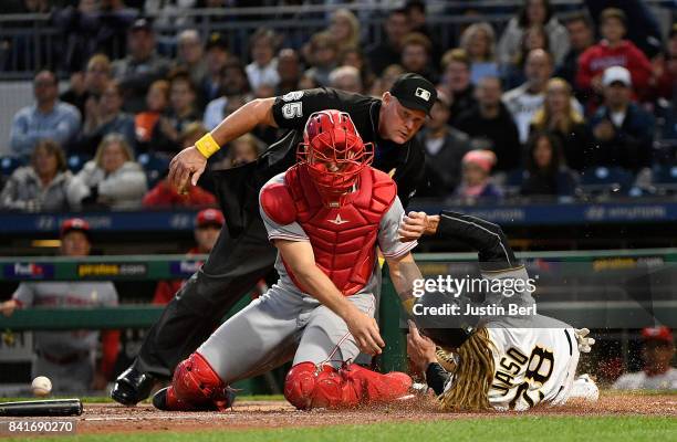 John Jaso of the Pittsburgh Pirates slides safely past Stuart Turner of the Cincinnati Reds to score in the second inning during the game at PNC Park...