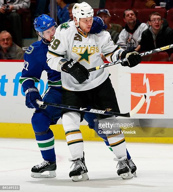 Daniel Sedin of the Vancouver Canucks grabs onto Steve Ott of the Dallas Stars during their game at General Motors Place on January 4, 2009 in...