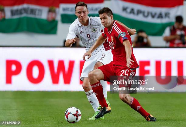 Richard Guzmics of Hungary competes for the ball with Davis Ikaunieks of Latvia during the FIFA 2018 World Cup Qualifier match between Hungary and...