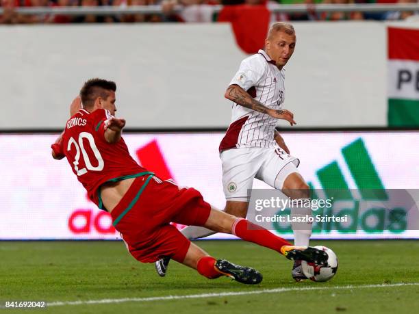 Richard Guzmics of Hungary slide tackles Deniss Rakels of Latvia during the FIFA 2018 World Cup Qualifier match between Hungary and Latvia at...