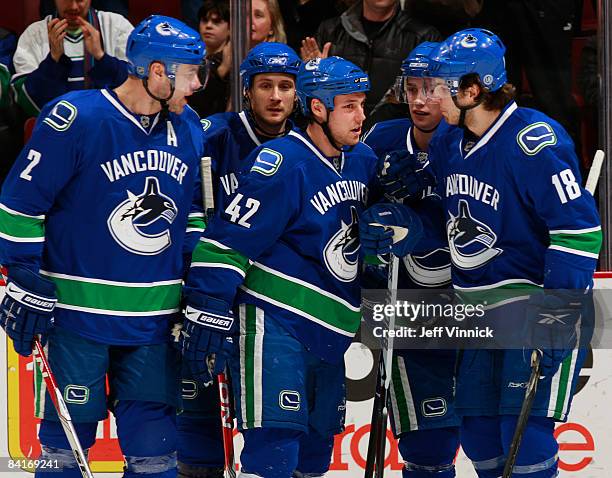 Kyle Wellwood of the Vancouver Canucks is congratulated by teammates Mattias Ohlund, Lawrence Nycholat, Mason Raymond and Steve Bernier after scoring...