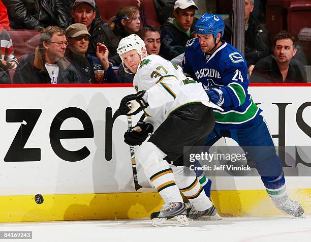 Mark Parrish of the Dallas Stars and Darcy Hordichuk of the Vancouver Canucks watch a loose puck during their game at General Motors Place on January...