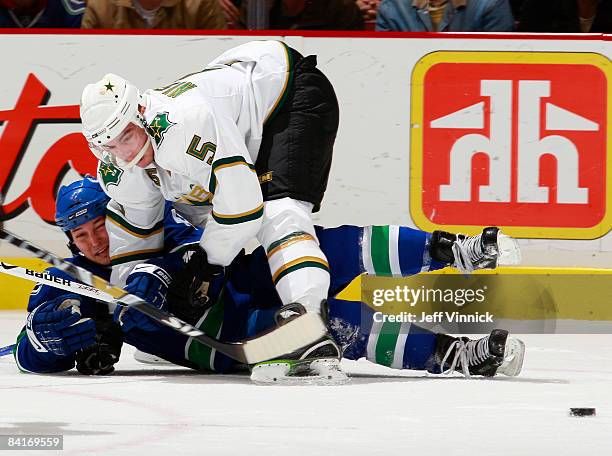 Kyle Wellwood of the Vancouver Canucks is checked to the ice by Matt Niskanen of the Dallas Stars during their game at General Motors Place on...