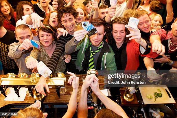 riotous drinking party in public bar  - huddle stock pictures, royalty-free photos & images