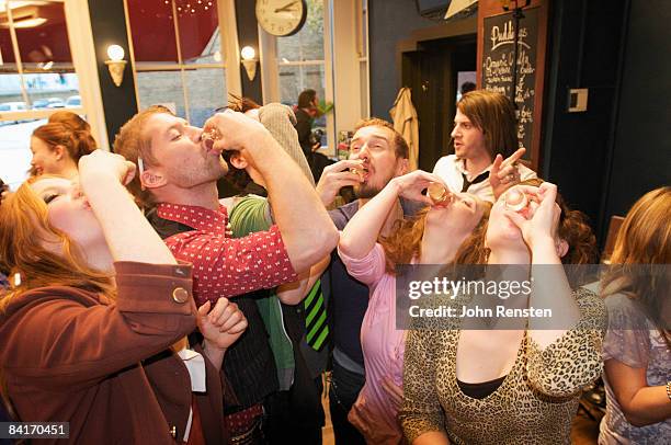 riotous drinking party in public bar  - woman binge drinking stock pictures, royalty-free photos & images