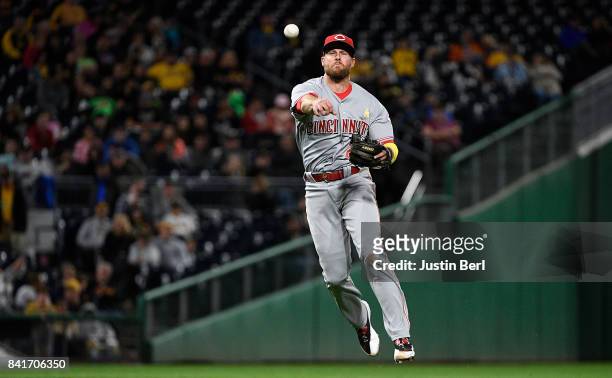 Zack Cozart of the Cincinnati Reds throws to first base for a force out of Elias Diaz of the Pittsburgh Pirates in the seventh inning during the game...