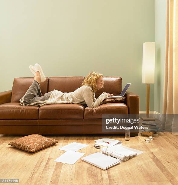 young woman using laptop on sofa. - prono foto e immagini stock