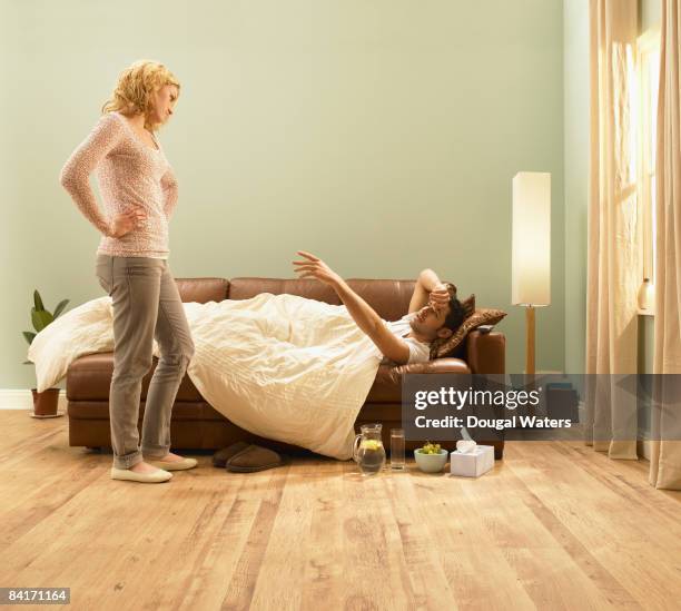 young man ill on sofa. - illness stock pictures, royalty-free photos & images