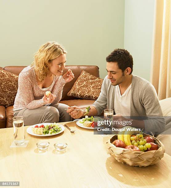 young couple eating fresh food. - three quarter length stock pictures, royalty-free photos & images