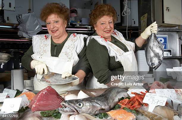 twin fishmongers at stall - fish market stock pictures, royalty-free photos & images
