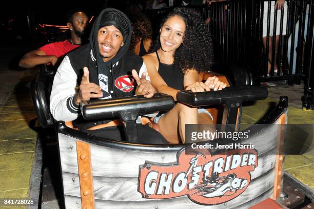 Actor Nick Cannon and Brittany Bell ride the 'Ghostrider' Roller Coaster at Knott's Berry Farm on September 1, 2017 in Buena Park, California.