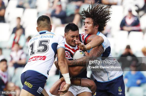 Zane Tetevano of the Roosters is tackled by Nathaniel Peteru and Kevin Proctor of the Titans during the round 26 NRL match between the Sydney...