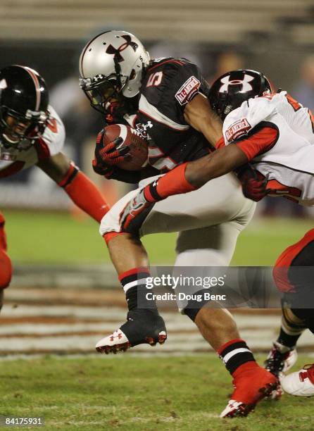 Running back Jaamal Berry of the black team is brought down before fumbling in the All America Under Armour Football Game at Florida Citrus Bowl on...