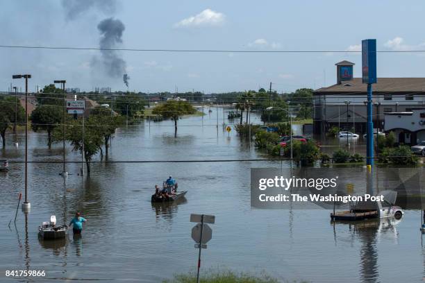 Boats and abandoned vehicles line Jimmy Johnson Boulevard in Port Arthur, Texas on September 1, 2017. The smoke at rear is rising from a nearby...